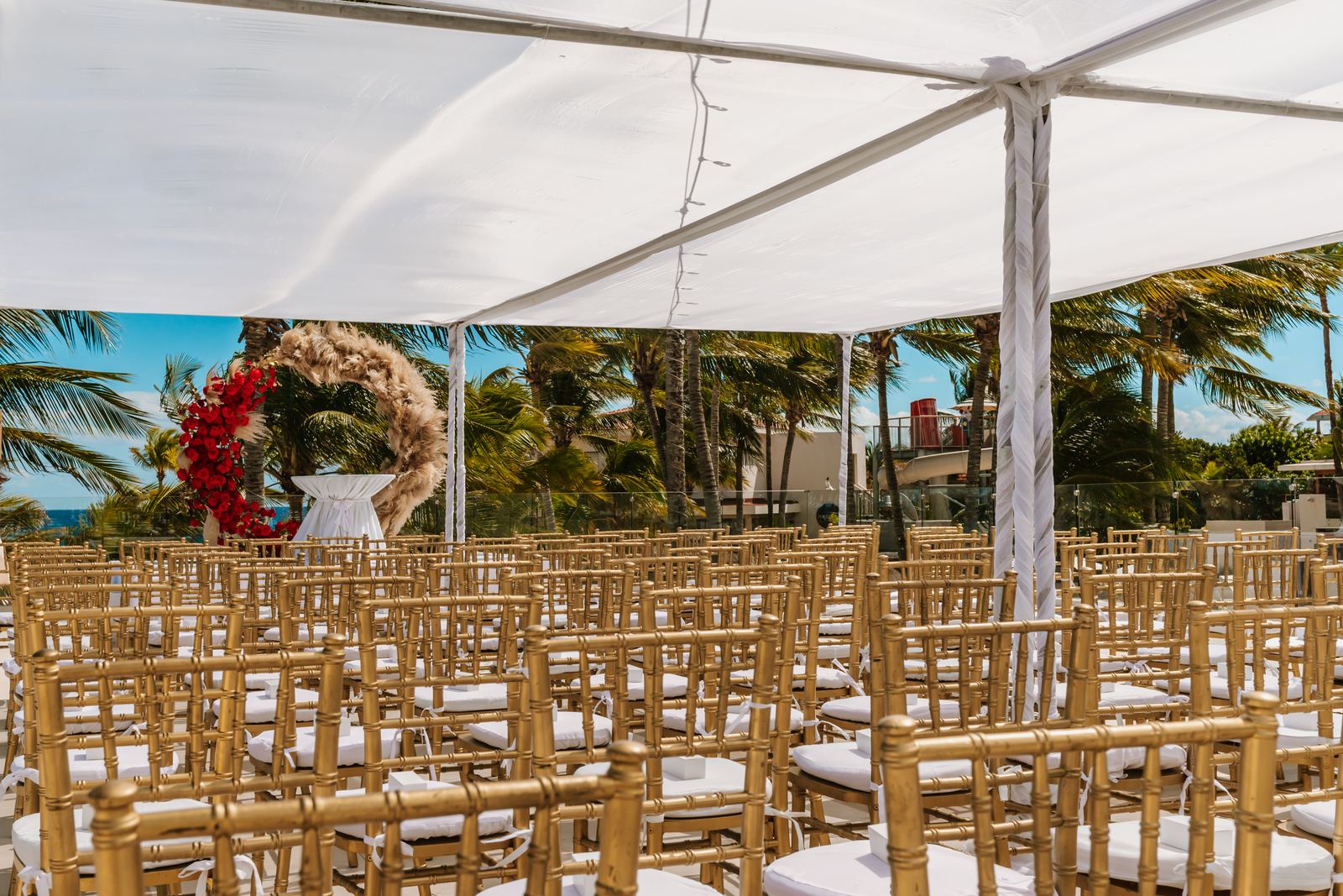 Gold chairs set under a white canopy before the Catholic ceremony